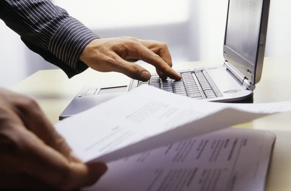businessman-looking-at-papers-while-using-laptop-2026-01-11-09-55-02-utc (1).jpg